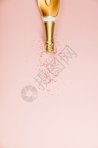纯净的庆典香槟瓶加喷洒粉红色背景的喷洒图片
