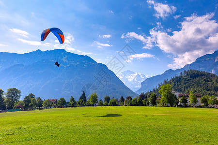禁烟区域提示语在瑞士伯尔尼高地重要旅游中心因特拉肯市的霍赫马特公园飞行的一架滑翔机背景