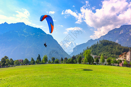 霍赫米特在瑞士伯尔尼高地重要旅游中心因特拉肯市的霍赫马特公园飞行的一架滑翔机背景