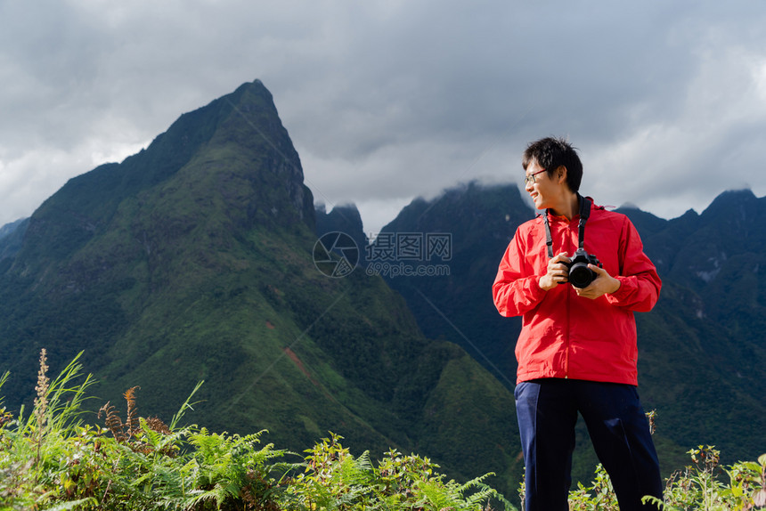 一名亚洲旅游男子在越南萨帕Sapa的旅游行和假期概念中夏季在Fansipan山上与稻田谷一起观望图片