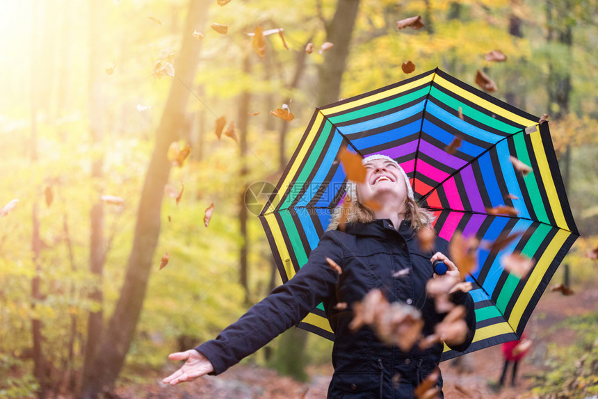 在秋天的森林里带着多彩的雨伞漂亮女孩叶子掉下来了图片