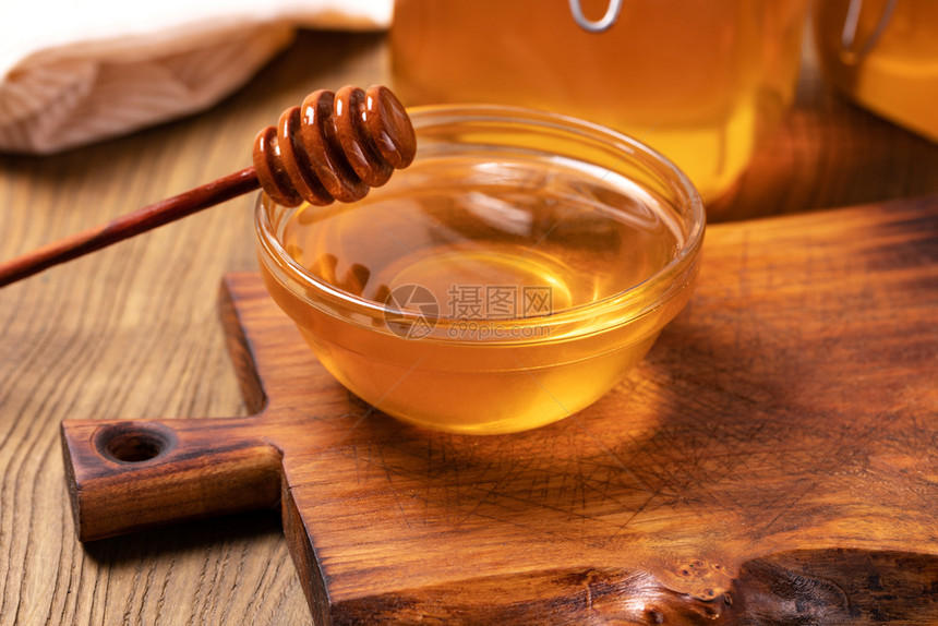 蜂蜜在木制桌上被孤立图片