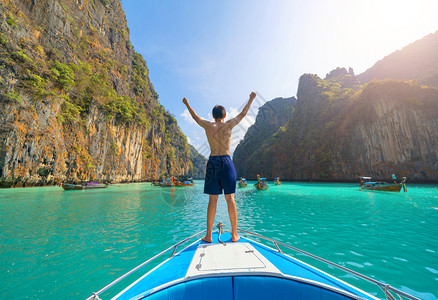 一名亚洲男子旅游者在暑假行期间在普吉岛的克拉比PhuketIsland夏季乘游假旅行蓝绿的海水坐船在克拉比Krabi俯冲或潜水背景图片