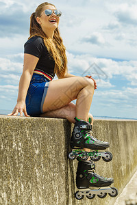 快乐的年轻女子穿着滑冰鞋在长途旅行后放松快乐的年轻女子穿着滚冰鞋图片