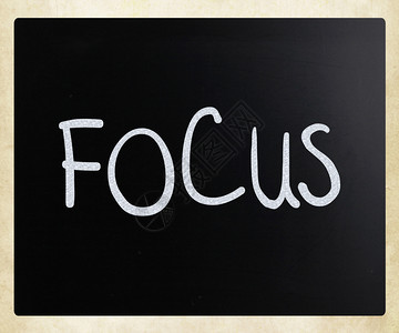 Focus这个词用黑板上的白粉笔手写图片
