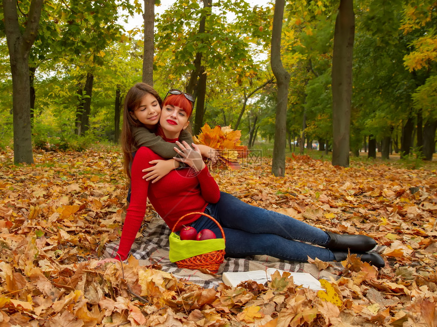 穿着明亮毛衣的年轻母亲和小女儿在大自然野餐时放松图片