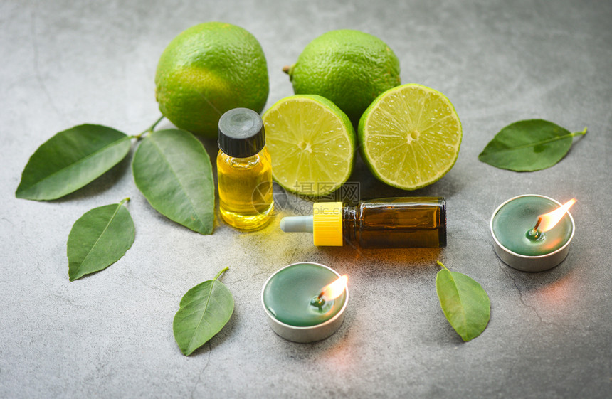 Aroma治疗草药油瓶含柠檬叶的芳香水配有蜡烛方顶视黑底天然必需油和绿叶有机平地图片
