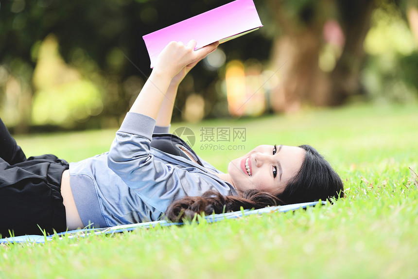 女孩躺在草地上读书图片