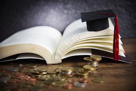 板件典礼教育概念奖学金在黑底木上用硬币在一本公开书上以毕业限背景
