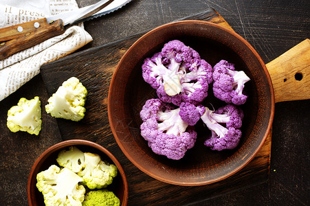 紫色西兰花碗中的鲜菜花棕碗中的彩背景