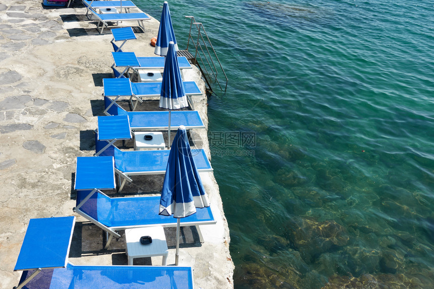海边度假胜地滩上有空甲板椅的海滩图片