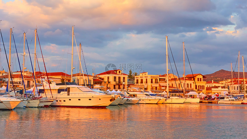 希腊萨罗尼群岛Aegina镇日落时港口和海滨的全景图片