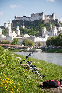 斜靠在萨尔茨堡河道草地的自行车图片