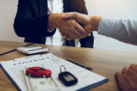 客户和汽车销售员握手达成协议图片