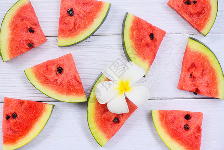 新鲜西瓜切片纹理背景西瓜无缝夏季水果和白花顶端视图图片