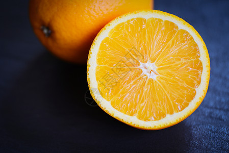 深底漆黑的新鲜橙子水果切片半图片