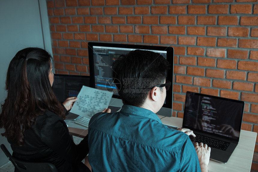 两名软件开发商正在使用计算机与其办公桌的合作伙伴图片