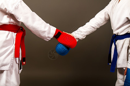 在基莫诺斯的两名小空手道女孩和比赛前红蓝握手的全套运动设备背景图片