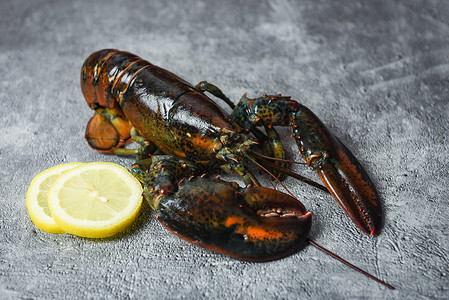 在海鲜餐厅的新龙虾贝壳鱼用于煮熟食品生龙虾和黑石桌上的柠檬有选择焦点图片