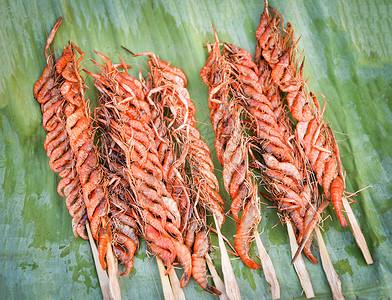 淡水小虾在街头食品市场对香蕉叶进行烧烤用棍棒和调味剂烤熟图片