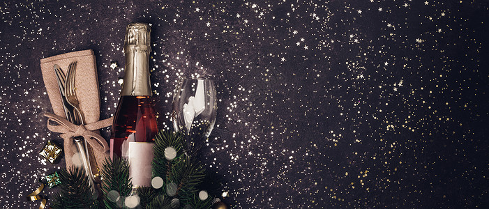 香槟酒瓶装着圣诞饰品在黑暗背景上平坦的党概念高清图片