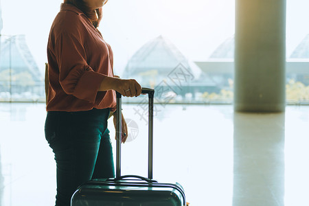 女乘客提着行李在机场候等候登机图片