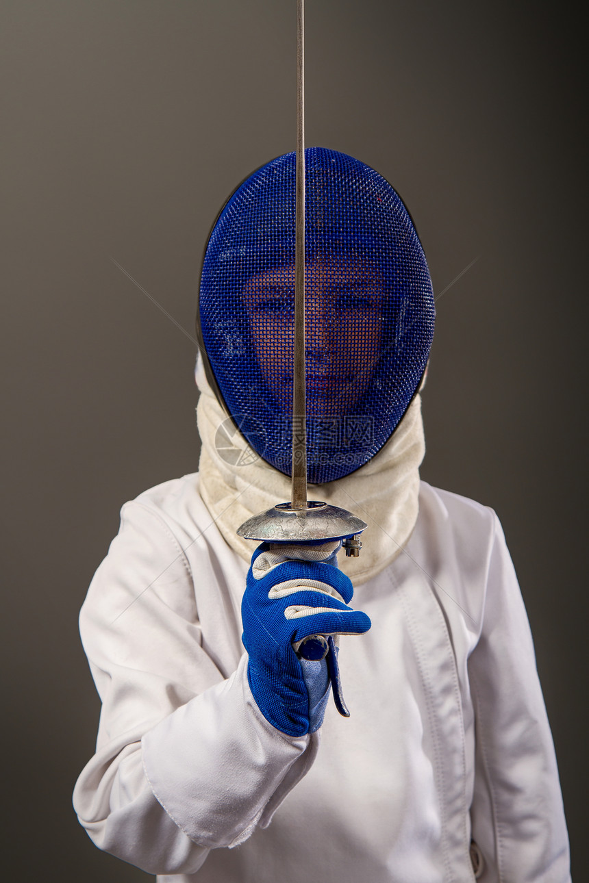 小男孩栅栏手持白色运动器材手持白色运动器材头戴保护盔背着黑暗景体育器材中的客图片
