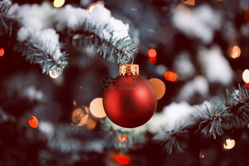 传统人造圣诞树带有红球装饰品有彩色闪光灯有古老形式的雪图片