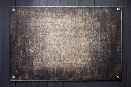 黑色背景纹理表面带有螺丝的木板图片