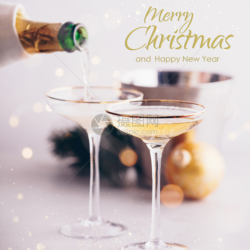香槟倒在杯子和圣诞装饰上放在混凝土背景上配有文字图片