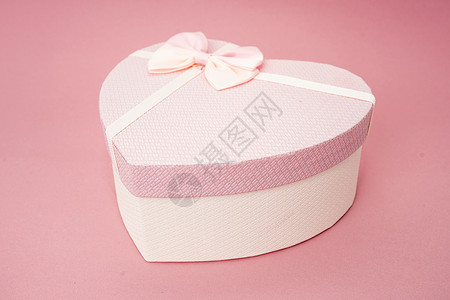 粉红背景的心形状礼物盒图片