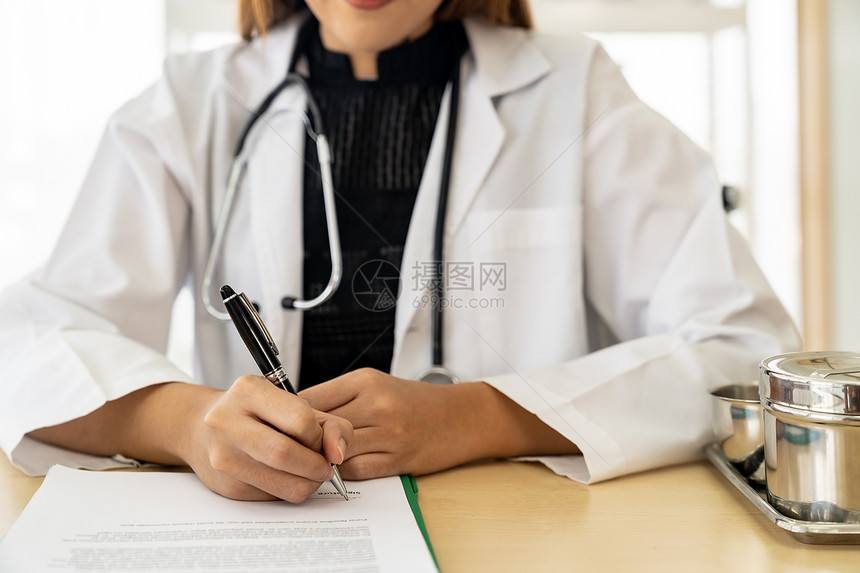 在医院诊所的检查室里有自信的女医生疗专业人员坐在医院诊所的检查室签署文件图片