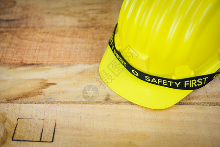 安全第一构想黄硬安全戴头盔帽子木背景工头盔图片