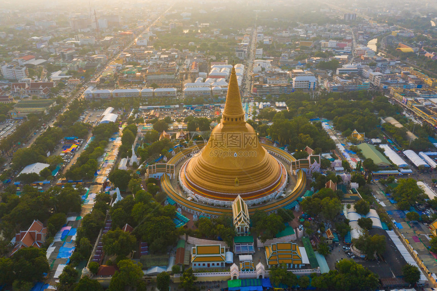 日落时的法拉路德玛迦迪寺庙空中最顶端景象带有住宅的金佛塔泰国纳科恩路德姆区城市圣泰建筑图片