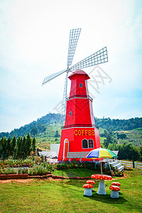 再力花花园公红风车力涡轮机台椅上挂有多彩雨伞咖啡店户外和山地背景背景