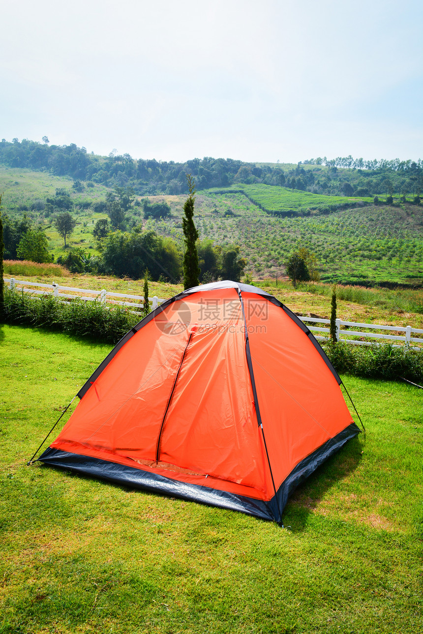 在绿草地上美丽的一排多彩色橙帐篷露营供游客旅行放松户外假日图片