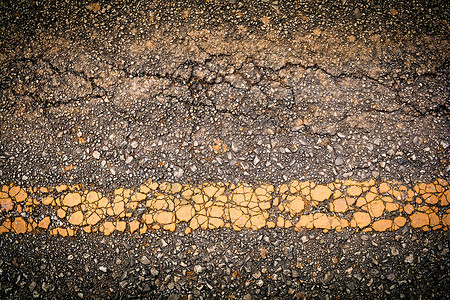Crack沥青旧公路纹理背景和黄线图片