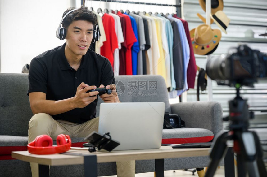 年轻亚洲男子在博客工作为互联网录制视频辅导图片