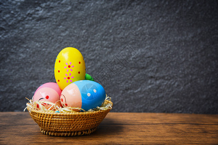 鸟巢篮中的复活节鸡蛋生锈桌木质和黑暗背景高清图片