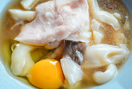 新鲜的鱼叉切片配鸡蛋和猪肉配有酱汁生鱿鱼海鲜做烧烤或Shabu图片