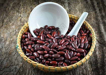 红豆阿祖基或肾生木背景的篮子和杯勺上红豆种子图片