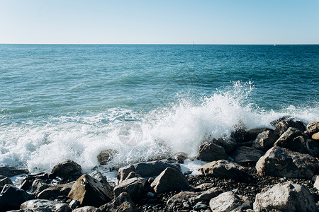 海滩上的石头浪冲向岸边的岩石美丽海景图片