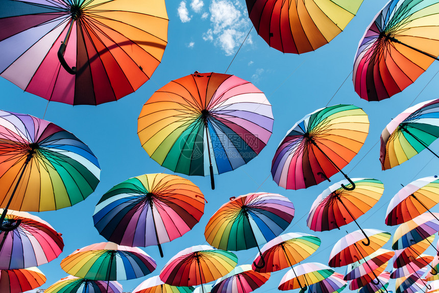 蓝天空背景彩虹颜色的伞状图片