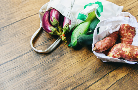 零废物使用较少塑料概念在木制桌上的生态棉花布袋中使用新鲜蔬菜有机制品市场免费塑料购物的白色拖布袋背景图片
