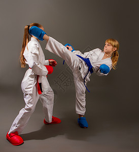 空手道制服空手道在红色的白和服中与两个小女孩战斗背景