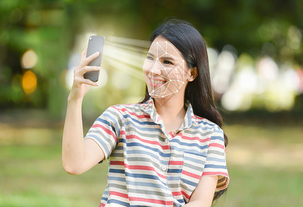 vi视觉识别系统智能手机生物鉴别筛查美丽的妇女微笑并使用移动电话面部识别系统扫描概念背景
