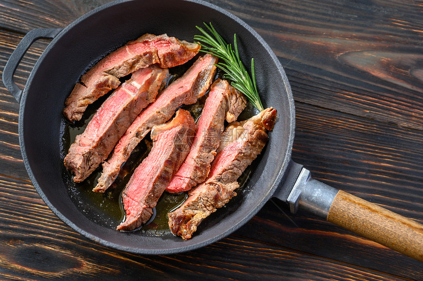 黑底牛肉排和草药香料迷迭在盘子上，好吃图片