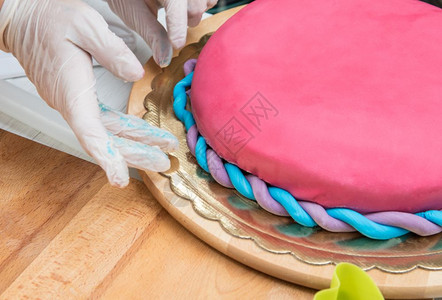 妇女制作和装饰蛋糕加糖糊图片