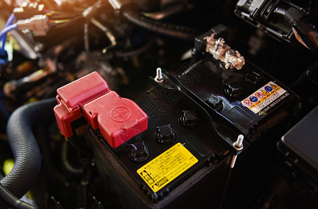 在汽车发动机舱里蓄电池的细节特写镜头背景图片