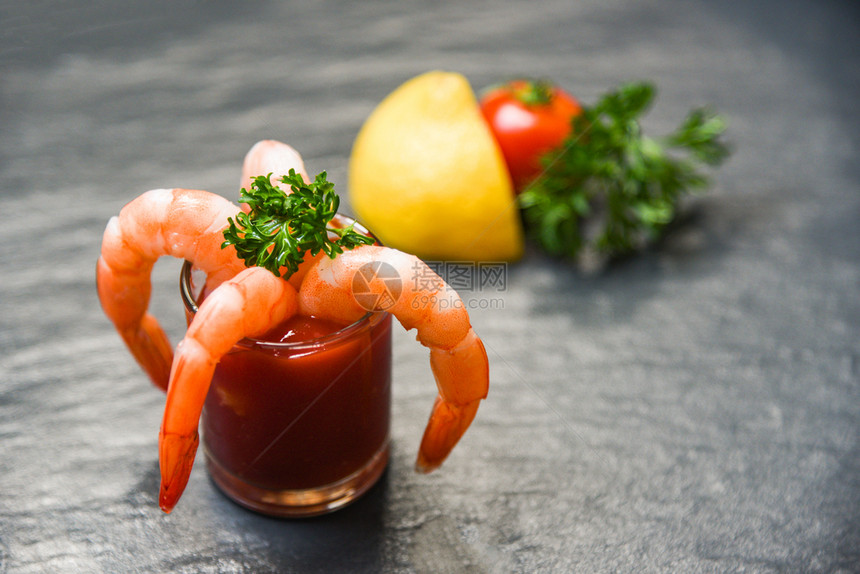 番茄酱中的玻璃虾鸡尾酒贝壳鱼海产鲜煮熟虾番茄酱海洋美食晚餐和深底番茄柠檬香料图片